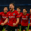 Hannover 96 players celebrating a goal against Schalke 04 at HDI Arena, showing team spirit and intense emotions during the Bundesliga 2 match.